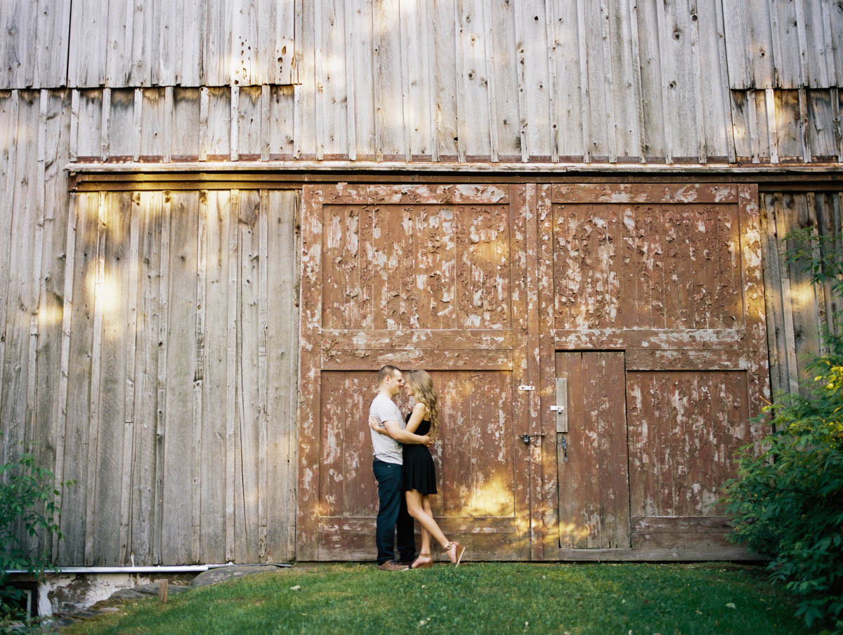 holding each other close in front of the barn doors