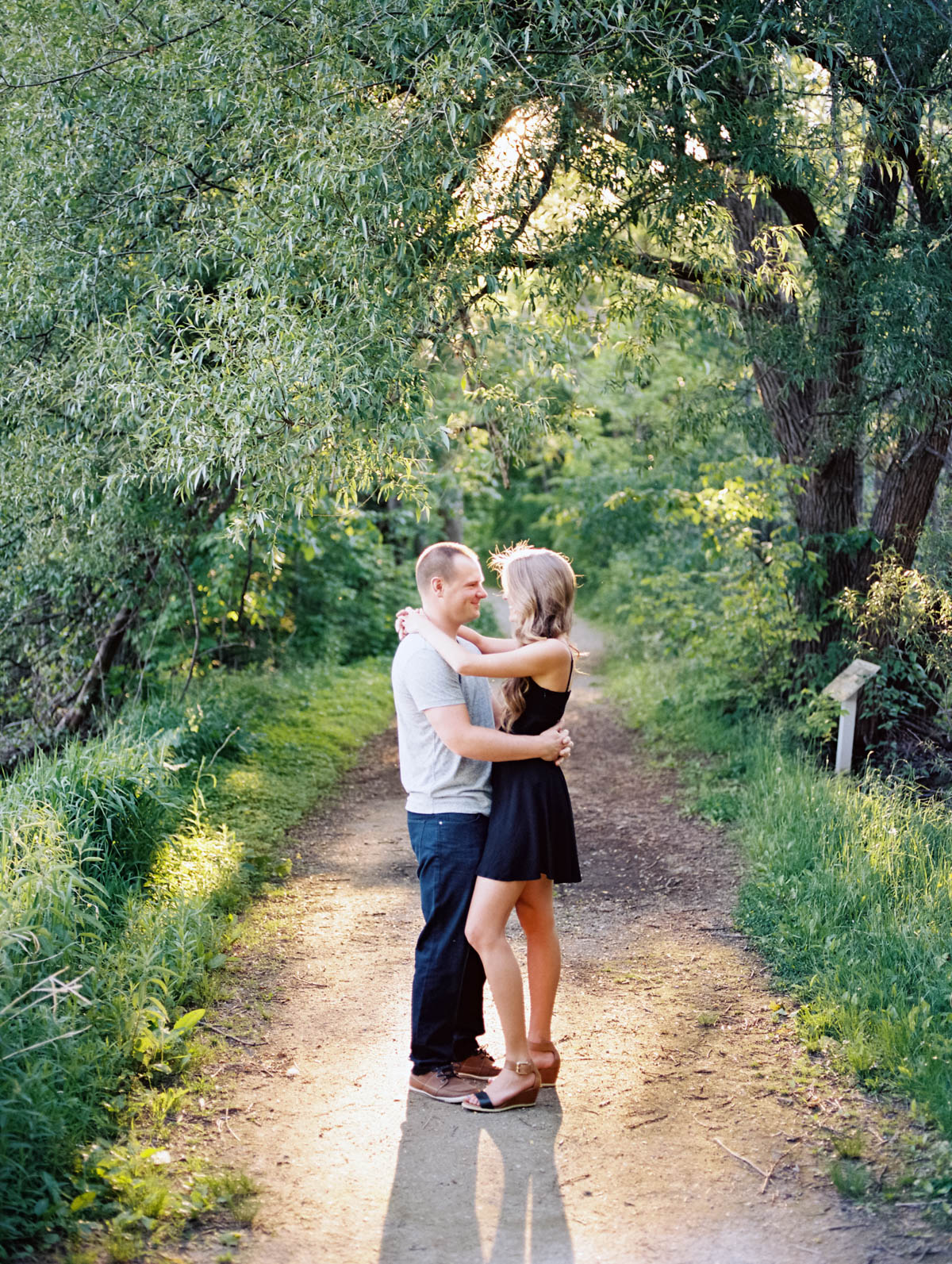 couple facing each other on a path during an engagement photography session at scotsdale farm