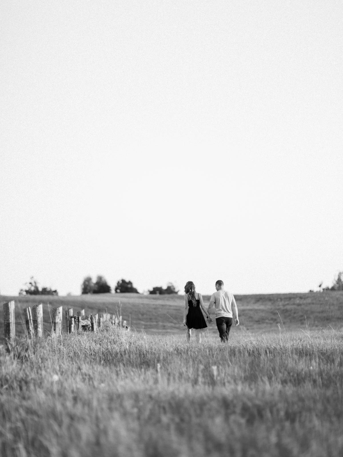 couple walking in a field, black and white