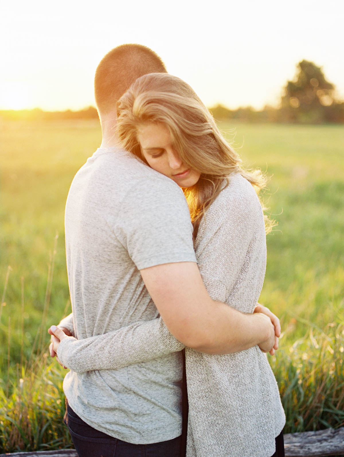 close embrace with a glowing sunset during an engagement photography session at scotsdale farm